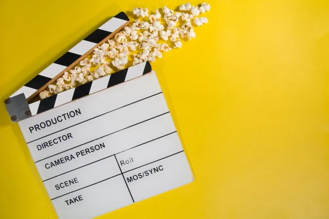 A photo of a clapperboard and popcorn.